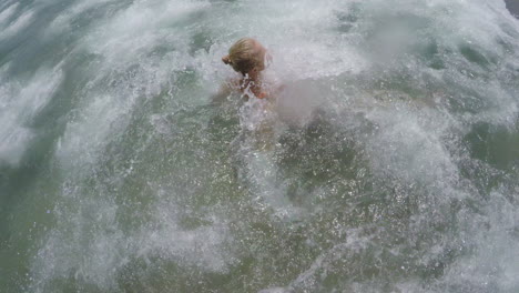 sea wave hitting swimming woman