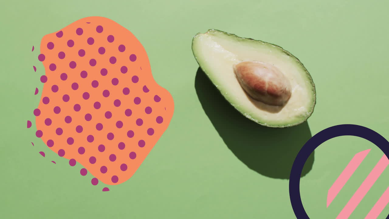 녹색 바탕에 반으로 개진 아보카도와 추상적인 모양의 구성