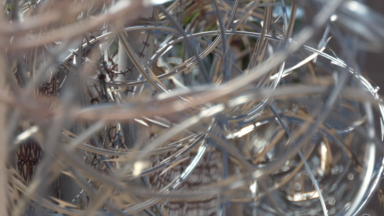 Barbed wire twisting along fence.