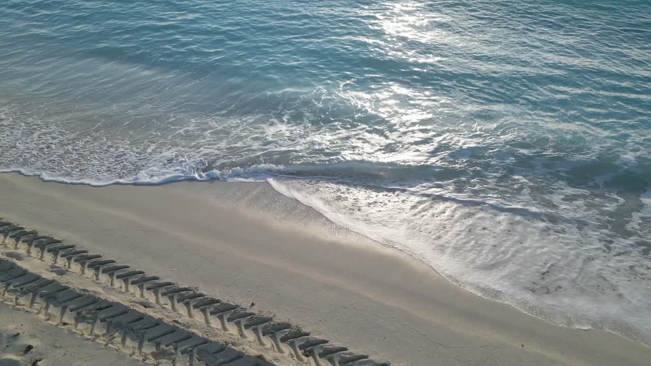 Beach waves and tire tracks at cancun’s shoreline, tranquil and scenic, aerial view, playa delfines