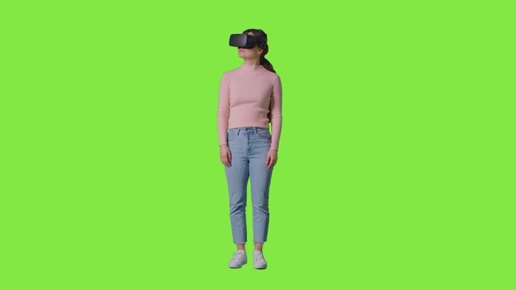 Inquadratura a figura intera di donna che indossa un visore di realtà virtuale e si guarda intorno su sfondo studio con schermo verde 1