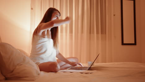 mujer trabajando en la computadora portátil en la cama por la noche