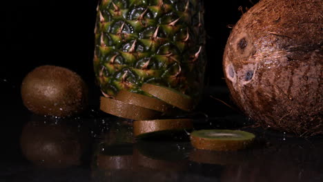 Kiwi-slices-falling-in-front-of-pineapple-and-coconut