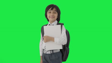 retrato de un niño de escuela indio feliz de pie con libros pantalla verde
