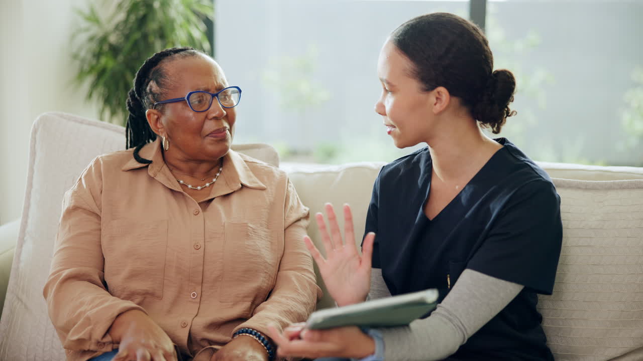 Professional Caregiver Consulting with Senior Woman Using a Tablet