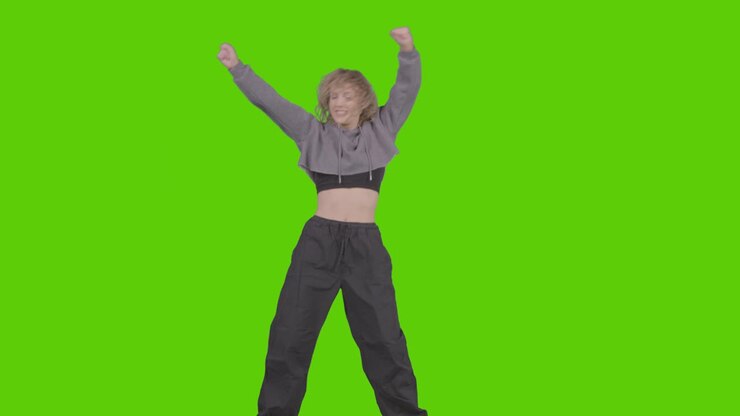 Studieoptagelse af ung kvinde, der danser og har det sjovt foran en grøn skærm 28