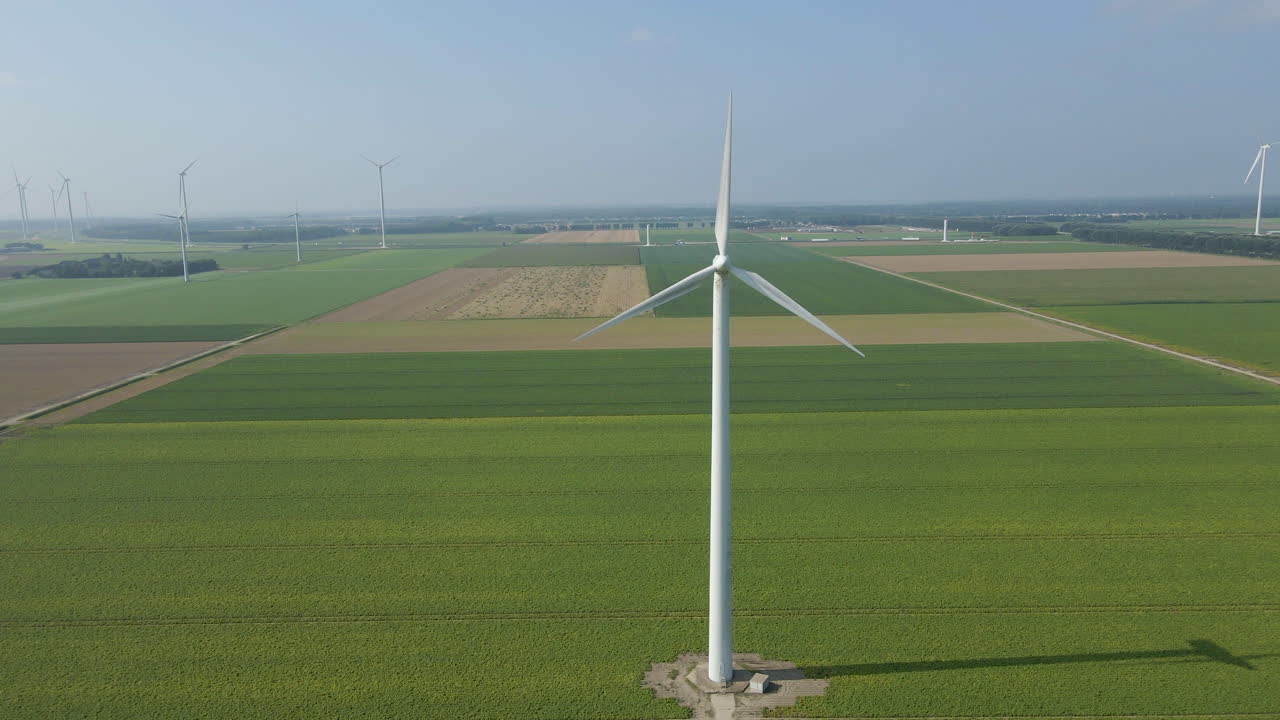 푸른 초원에 있는 큰 풍차 공원에 있는 회전하는 풍력 터빈의 지브