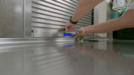 hand closing and locking an access panel to a cooking and kitchen area