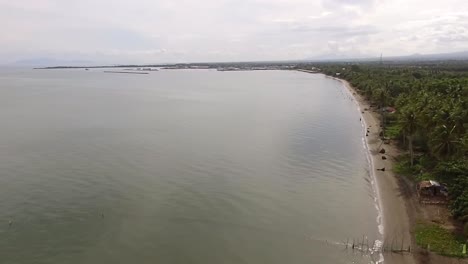 playa de arena vacía y hermoso mar tranquilo en un día nublado, drone aéreo