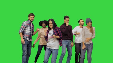 young lively beautiful girl dancing with the others at the party on a green screen, chroma key