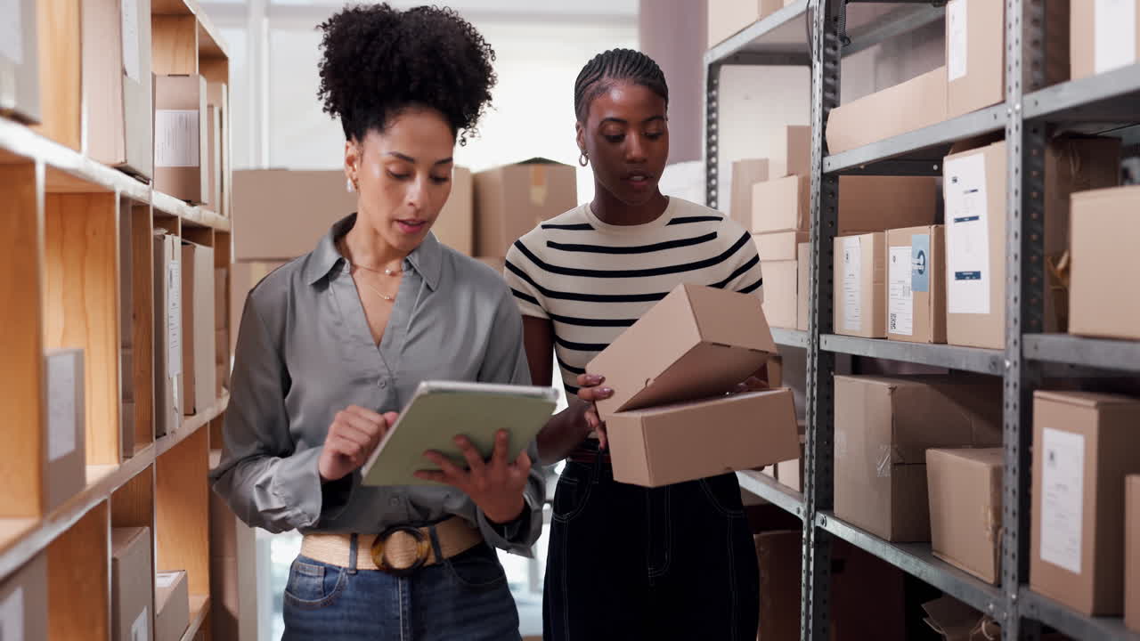 Due donne di diverse origini controllano l'inventario in un magazzino con un tablet