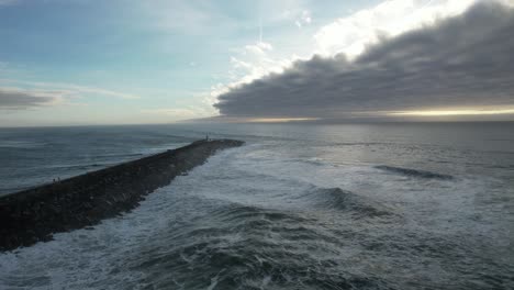 grandes olas rompiendo en las rocas al atardecer