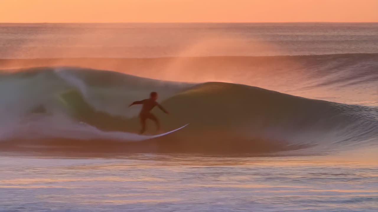 Surfer Riding Waves during Golden Hour