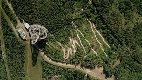 zoom aéreo en el punto de vista de un dron de una atracción de la torre sky walk dolni morava, república checa y un sendero para bicicletas mtb cercano