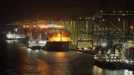 huge containership unloading shipments at singapore pasir panjang port at nighttime, static shot