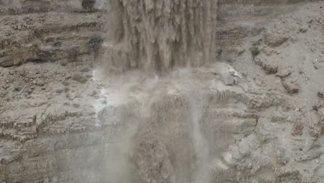 israel, powerful flood at the desert waterfall from a cliff, winter, drone shot