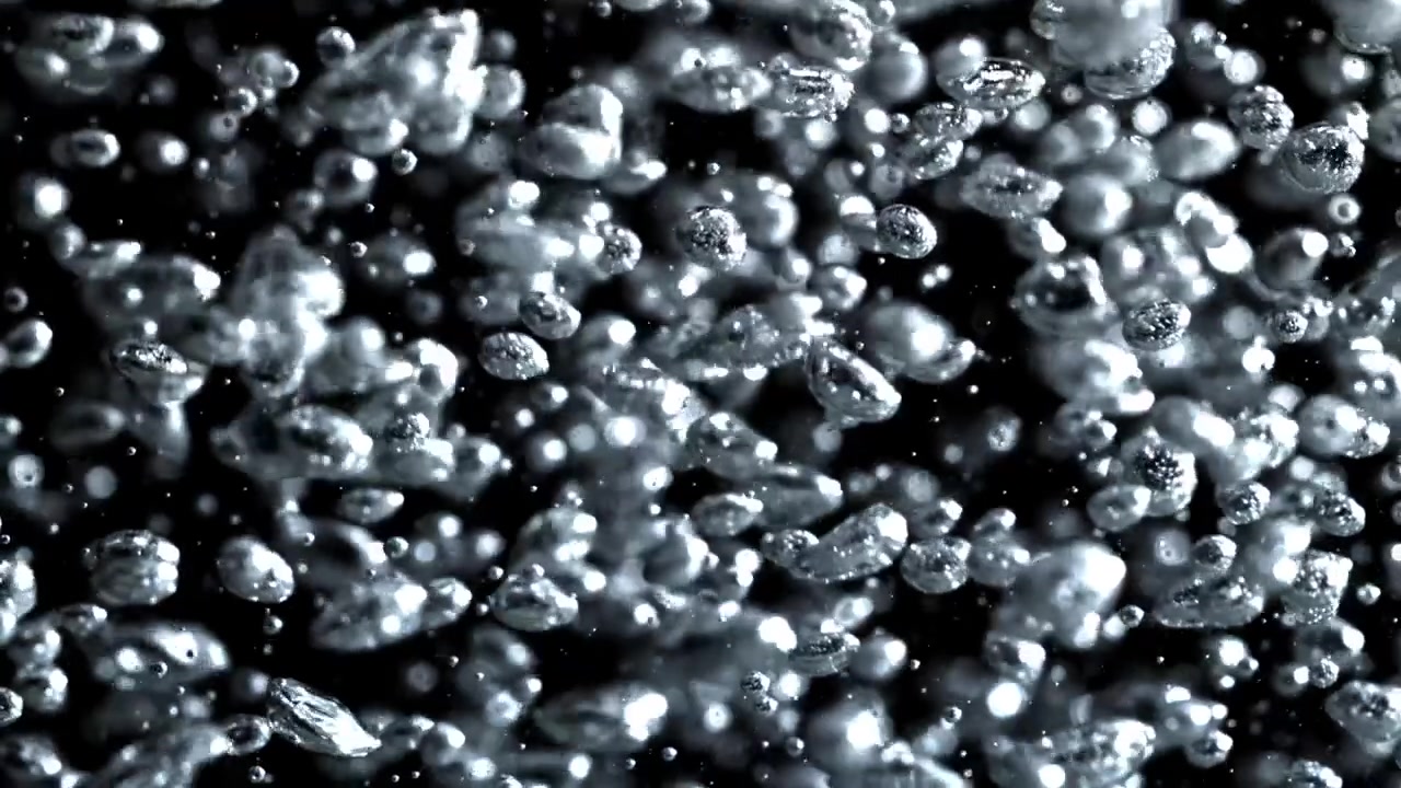 Bolle d'acqua limpida che salgono al rallentatore su sfondo nero