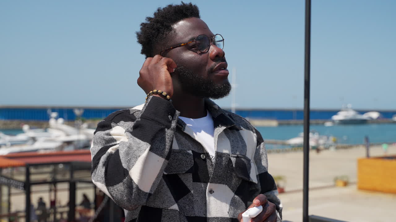 hombre escuchando música en un puerto