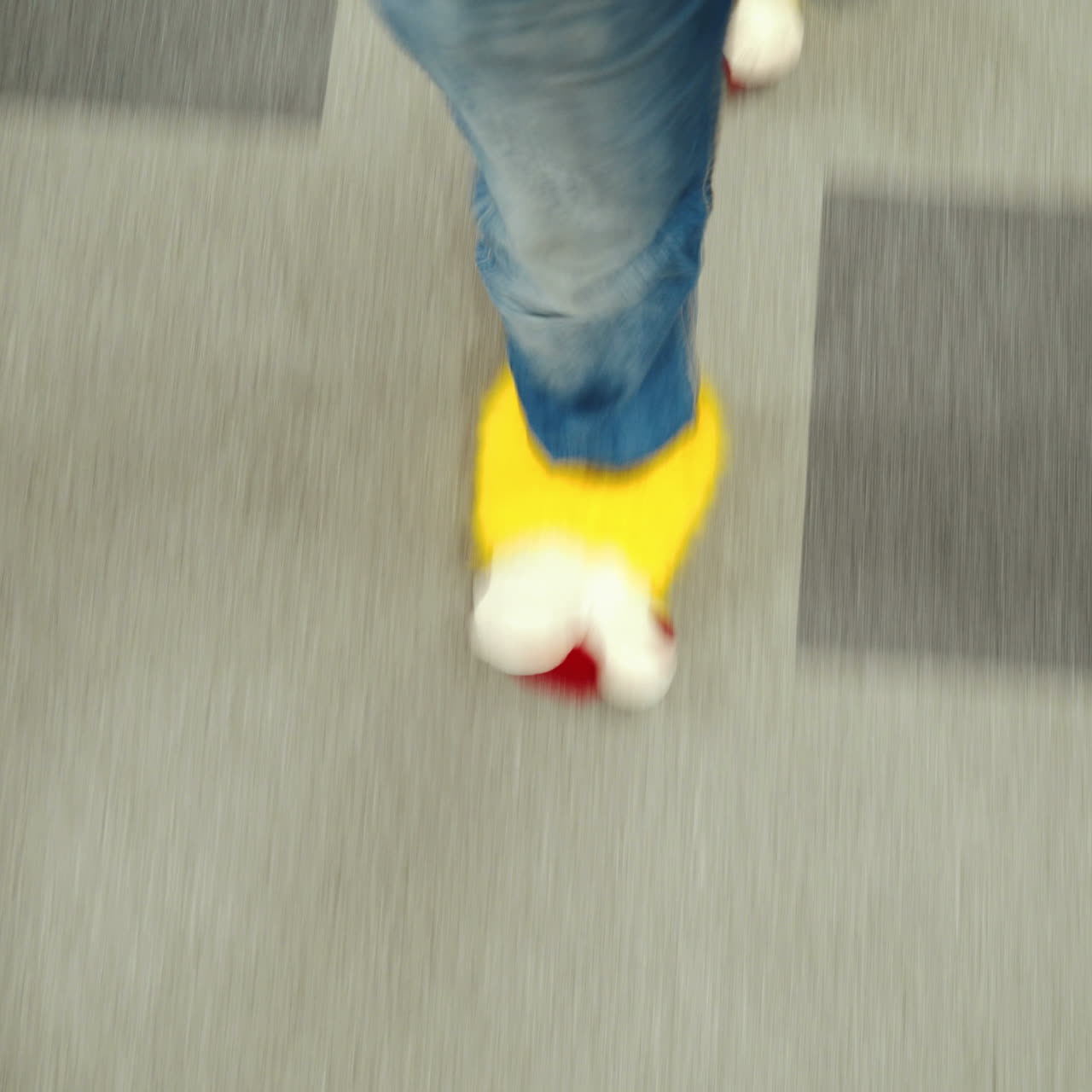 Office employee in funny yellow slippers. Male feet close-up walking through the office.