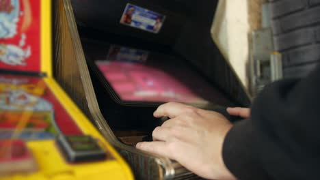 a man playing a vintage retro video game on a coin-op arcade machine