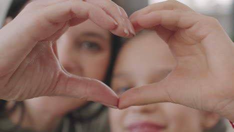 mother and child making heart shape with hands