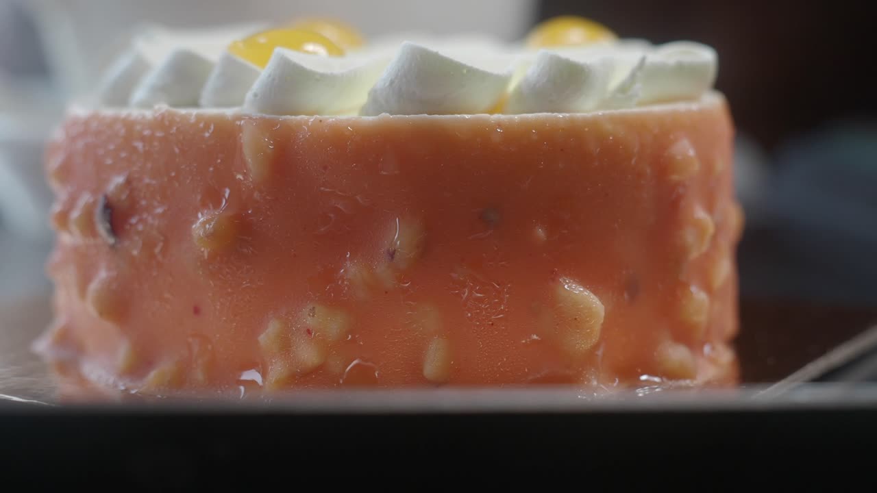 Primo piano di una piccola torta all'arancia con guarnizione di panna montata