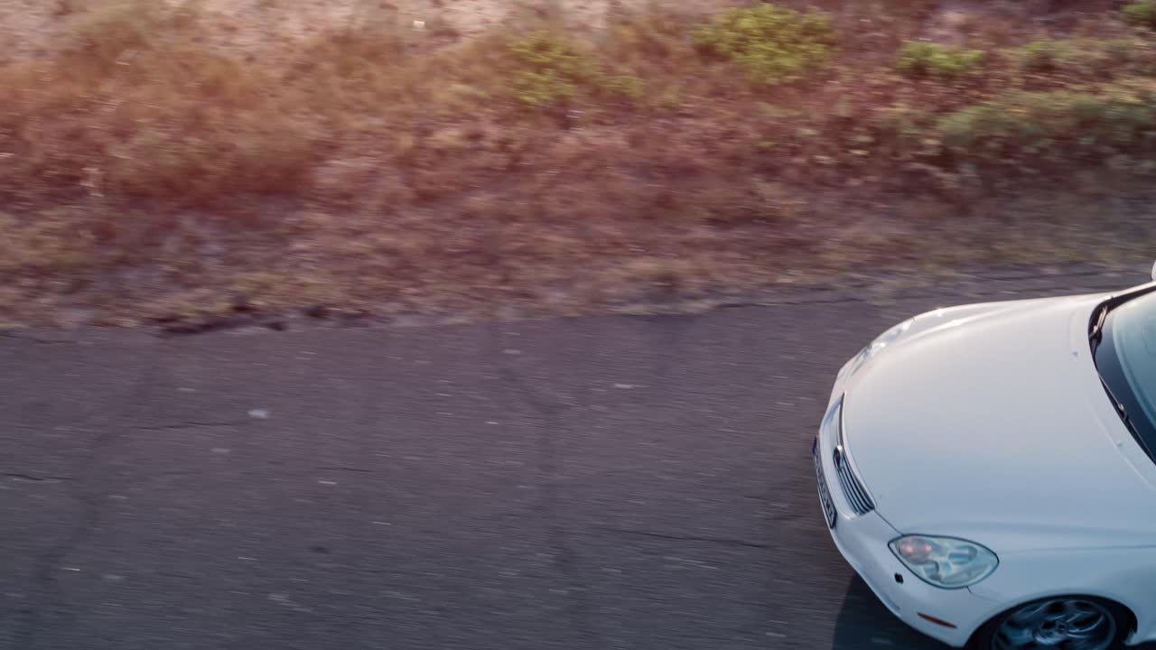 행복 한 부부 가 컨버터블 로 도로 여행 을 즐기고 있다