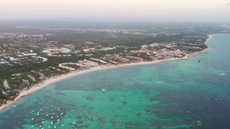 fila de resorts y botes en la playa de punta cana, república dominicana, panorámica aérea a la derecha, toma de revelación