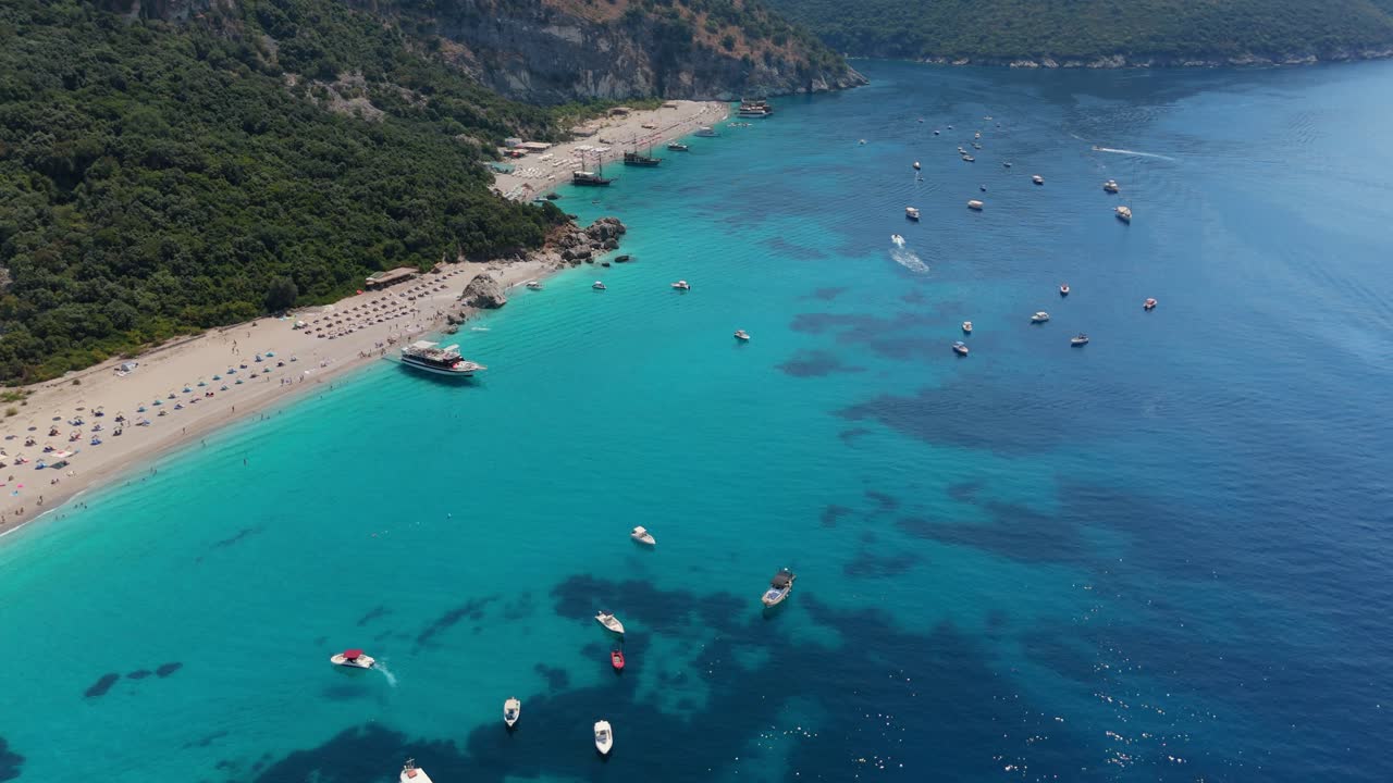 Boats floating on clear turquoise waters along the stunning beaches of Albania's coast