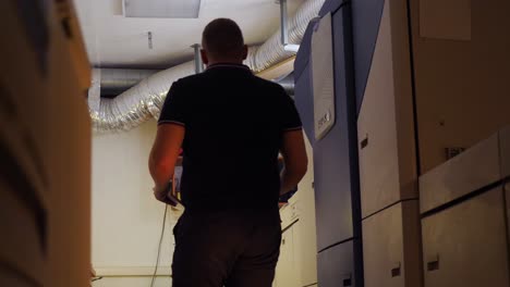 hombre caminando por una instalación de impresión