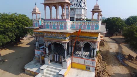 Aerial-pedestal-up-of-Hindu-temple-of-rural-Indian-village-of-Khera-Kiran-in-Rajasthan,-India