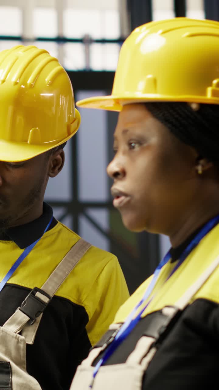 Vertical video Smart factory manager overseeing work done by engineer calibrating machinery