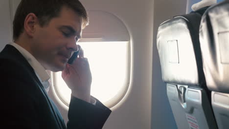 young man having a business phone talk in plane