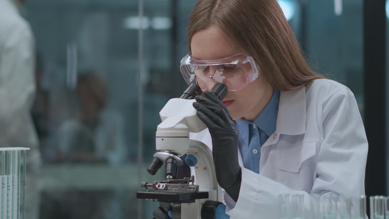 female doctor is exploring analysis of patient using microscope in laboratory DNA blood and genetic engineering research medical lab with modern equipment