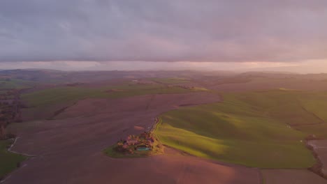 colinas onduladas de la toscana al atardecer con villa de lujo casa de granja, antena