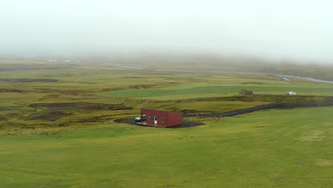 destino de viaje de cabina roja en medio del ambiente verde húmedo de islandia