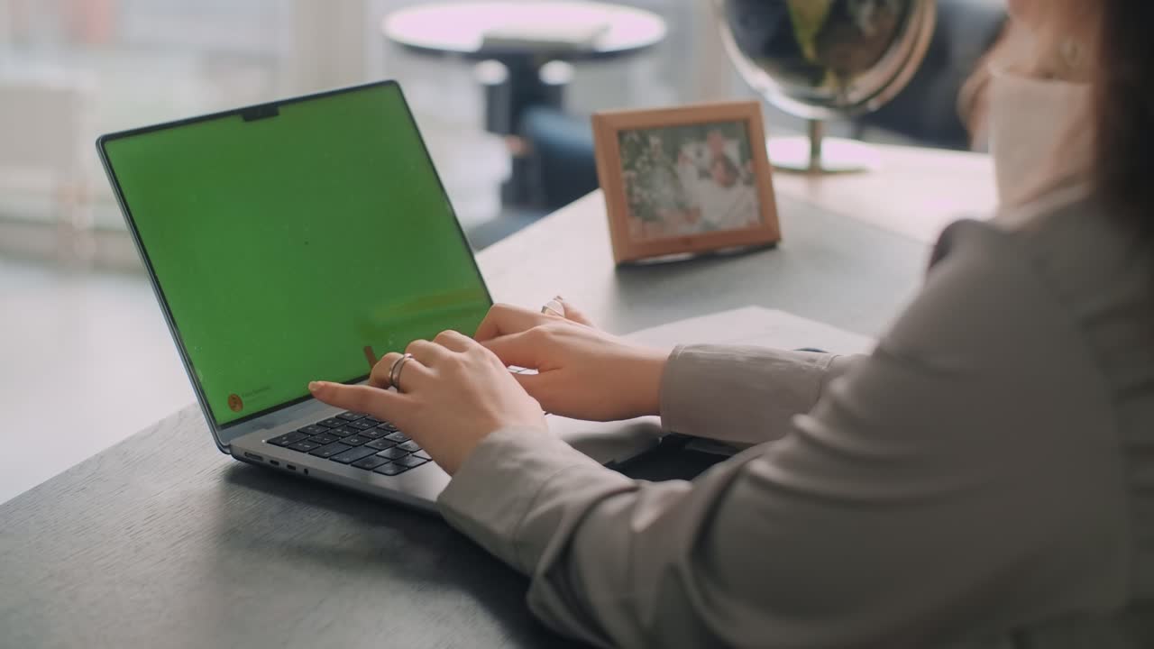 mujer trabajando en una computadora portátil con pantalla verde