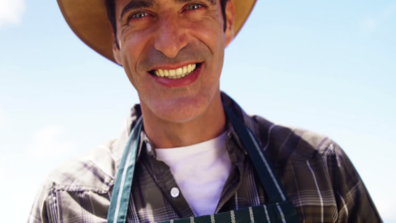 retrato de un hombre sonriente sosteniendo una caja de higos en el campo