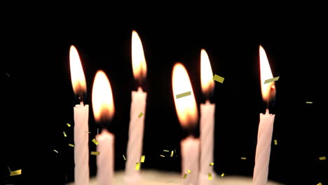 golden confetti falling over multiple burning candles against black background