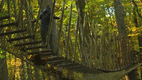 Chica-Trepa-Por-El-Puente-De-Cuerda-En-Un-Día-Soleado-De-Otoño