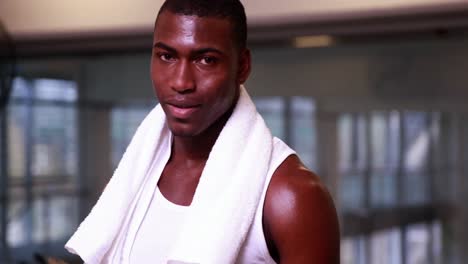 fit man taking a drink of water and smiling at camera