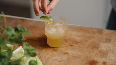 Young-male-decorating-a-cocktail-with-slice-of-lime