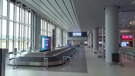 in the daytime at istanbul airport's baggage claim terminal, a drone-like low-to-high-angle, the scene