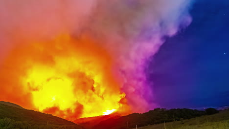 Timelapse-shot-of-an-intense-wildfire-behind-the-mountains-at-night