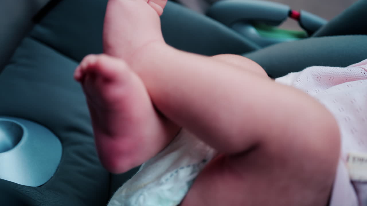 Primo piano delle gambe e delle piccole mani di un bambino seduto in un passeggino