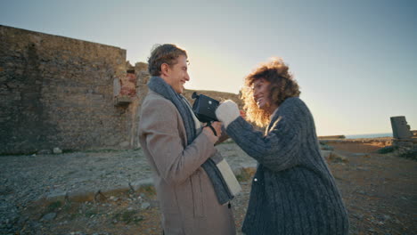 happy couple photographing together at sunset cliff closeup. man filming woman