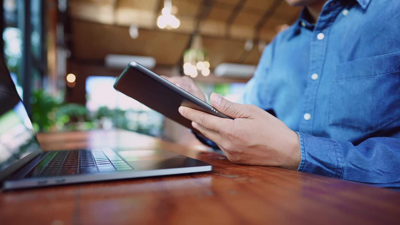un joven empresario que usa una máscara quirúrgica está haciendo una videoconferencia con los clientes a través de una tableta que está conectada a internet