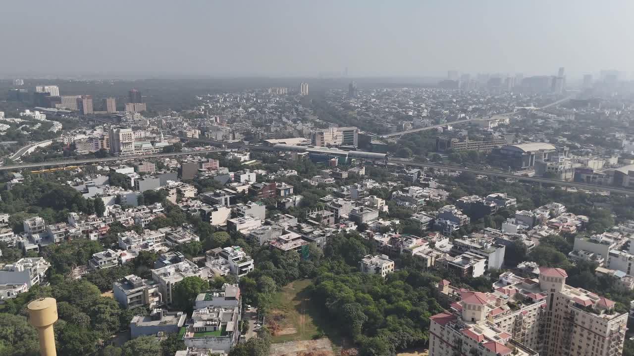Drone footage of flowing expressway traffic beside huge commercial blocks in Haryana’s business hub
