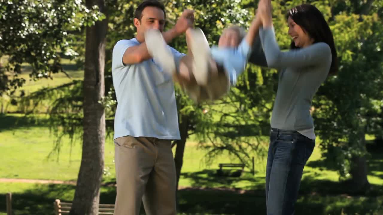 부모님이 아들을 흔들고 있습니다.