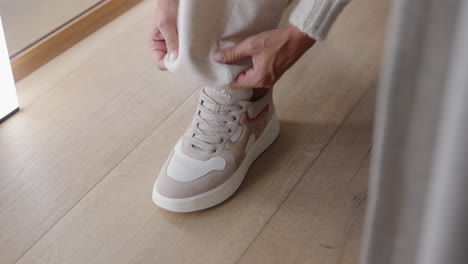 closeup of woman putting on beige shoes in store cabin